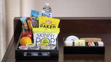 Un vassoio con snack, una bottiglia d'acqua e diversi prodotti alimentari.