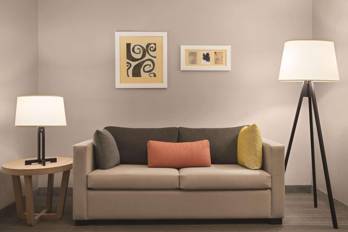 A neutral-toned room with a sofa, two side tables, and a floor lamp.