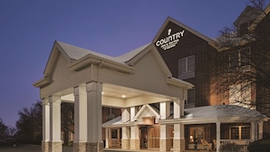 A Country Inn & Suites by Radisson with a covered outdoor area and brick facade.