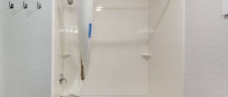 A modern bathroom with a walk-in shower, a bathtub, and a toilet.
