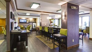 En hotellobby med en receptionsdisk, en sittgrupp och en tv som är monterad på väggen.