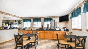 Una cocina con una isla central, armarios de madera y un televisor montado sobre la isla.