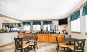 A kitchen with a central island, wooden cabinets, and a television mounted above the island.