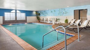 An indoor swimming pool with clear water, surrounded by lounge chairs and a mural of trees on the wall. - Country Inn & Suites by Radisson, Lexington, KY (Lexington)
