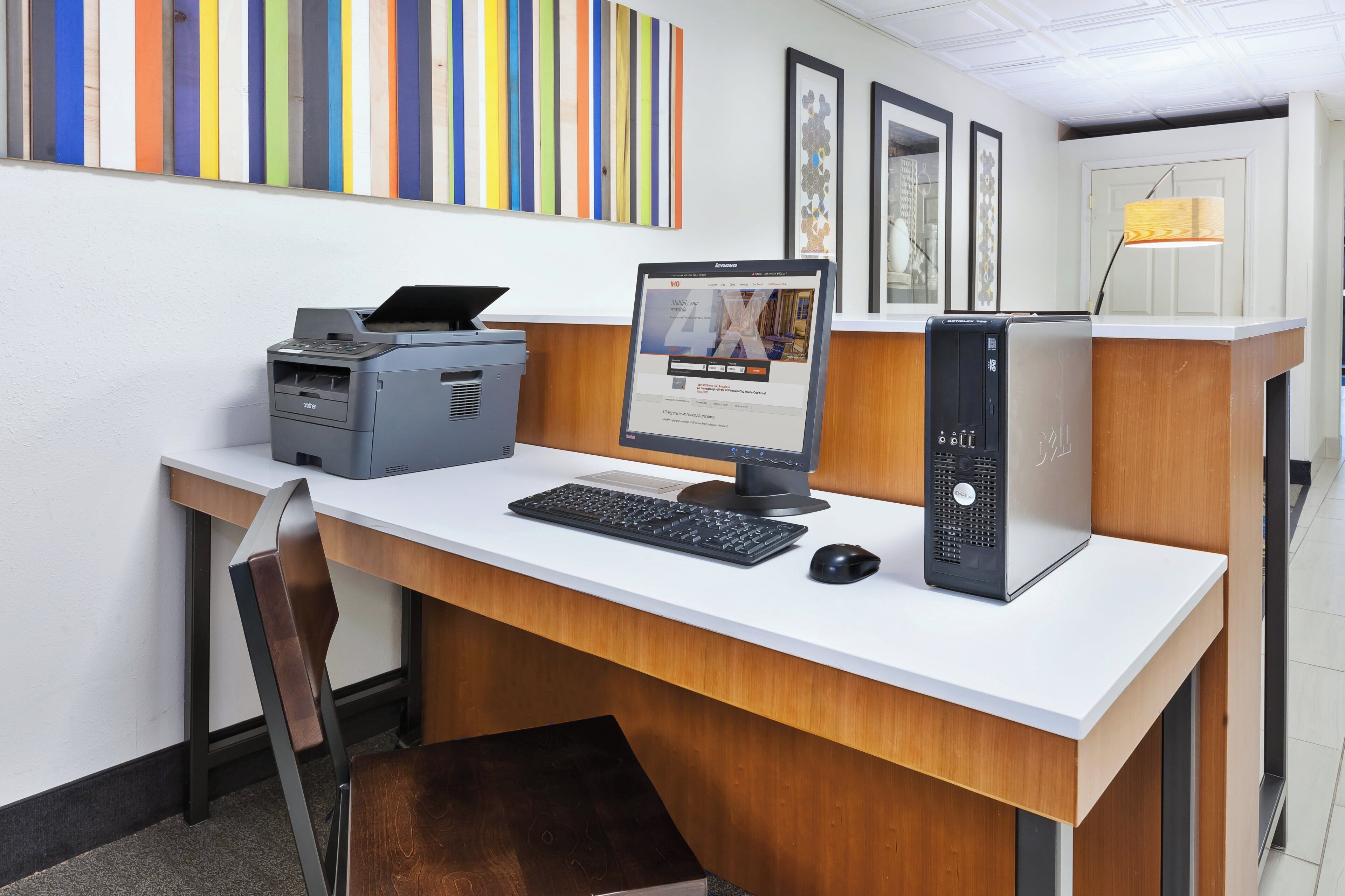 A modern office desk with a desktop computer, a printer, and a monitor.