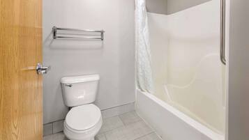 A bathroom with a toilet, a shower with a glass door, and a towel rack.