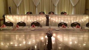 Una mesa de banquete dispuesta para un evento formal, con sillas y cubertería.