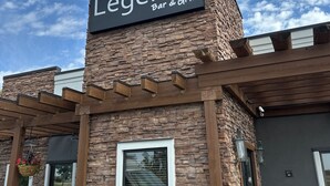 Un edificio con un cartel que dice 'Legends Bar & Grill' sobre una fachada de piedra.