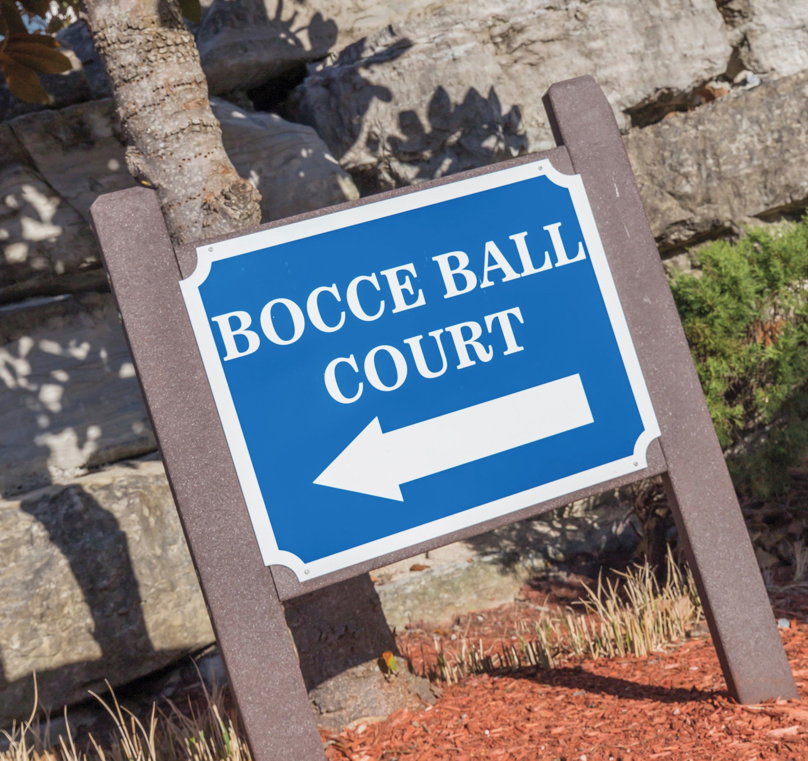 A directional sign for Bocce Ball Court with an arrow pointing to the left.