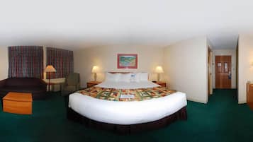 Une chambre d’hôtel avec un grand lit, deux lampes de chevet, une chaise, un canapé et un tableau au mur.
