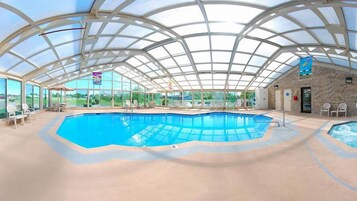 Una piscina techada, sillones reclinables de piscina