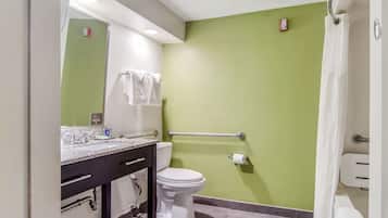 Ein Badezimmer mit grüner Wand, weißer Toilette und einer Marmorarbeitsplatte.