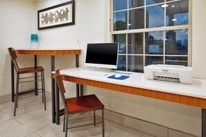 A workspace with a desk, two chairs, a computer, a printer, and a framed artwork on the wall. - Holiday Inn Express Hotel & Suites Sunbury - Columbus Area by IHG (Sunbury)