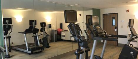 A gym with treadmills, elliptical machines, and a stationary bike.