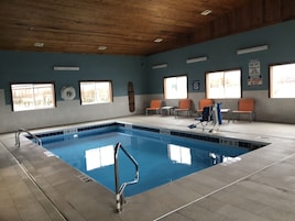 Una piscina techada, sillones reclinables de piscina