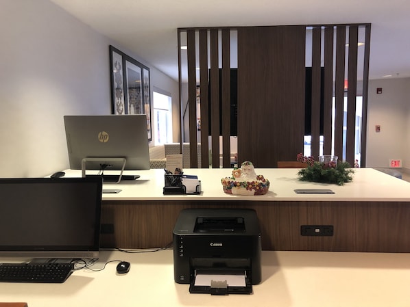 Un bureau moderne, équipé d’un ordinateur portable HP, d’une imprimante Canon et d’un objet décoratif en céramique.