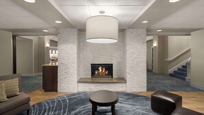 A modern lobby with a fireplace, a round table, and a sofa. - Homewood Suites by Hilton Hillsboro/Beaverton (Beaverton)