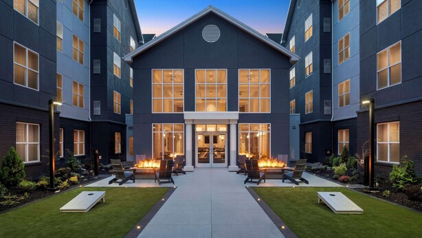 A modern hotel with a symmetrical facade, large windows, and a central entrance. - Homewood Suites by Hilton Hillsboro/Beaverton (Beaverton)