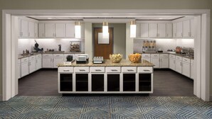 A modern kitchen with white cabinetry, a central island, and pendant lighting. - Homewood Suites by Hilton Hillsboro/Beaverton (Beaverton)
