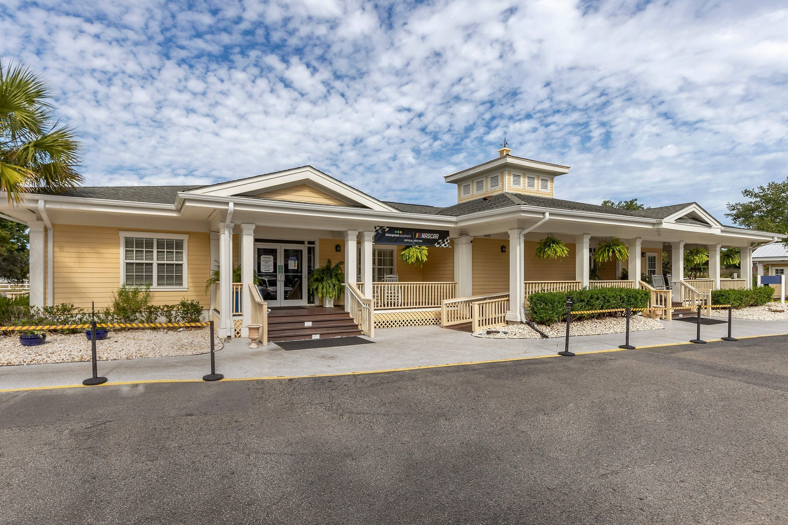 A two-story building with a covered entrance, a sign reading "Inns at the Inn", and a palm tree to the left.