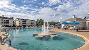 A swimming pool with a central fountain, surrounded by lounge chairs and umbrellas, with buildings in the background. - Bluegreen Vacations Harbour Lights, an Ascend Collection Resort (Myrtle Beach)