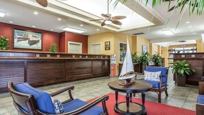 A lobby with wooden furniture, a sailboat model, and a reception desk. - Bluegreen Vacations Harbour Lights, an Ascend Collection Resort (Myrtle Beach)