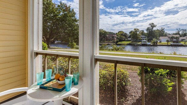 A view from a window overlooking a lake with houses and greenery. - Bluegreen Vacations Harbour Lights, an Ascend Collection Resort (Myrtle Beach)