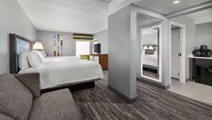 A modern hotel room with a large bed, a desk, a television, and a bathroom visible through an open door. - Hampton Inn Simpsonville (Simpsonville)