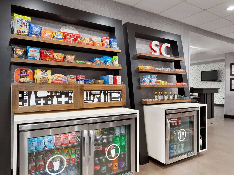 A snack display with various packaged foods and a refrigerated beverage dispenser.