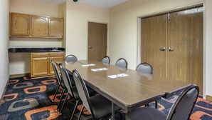 A conference room with a long table, chairs, a kitchenette, and a door. - Quality Inn Rogersville (Rogersville)
