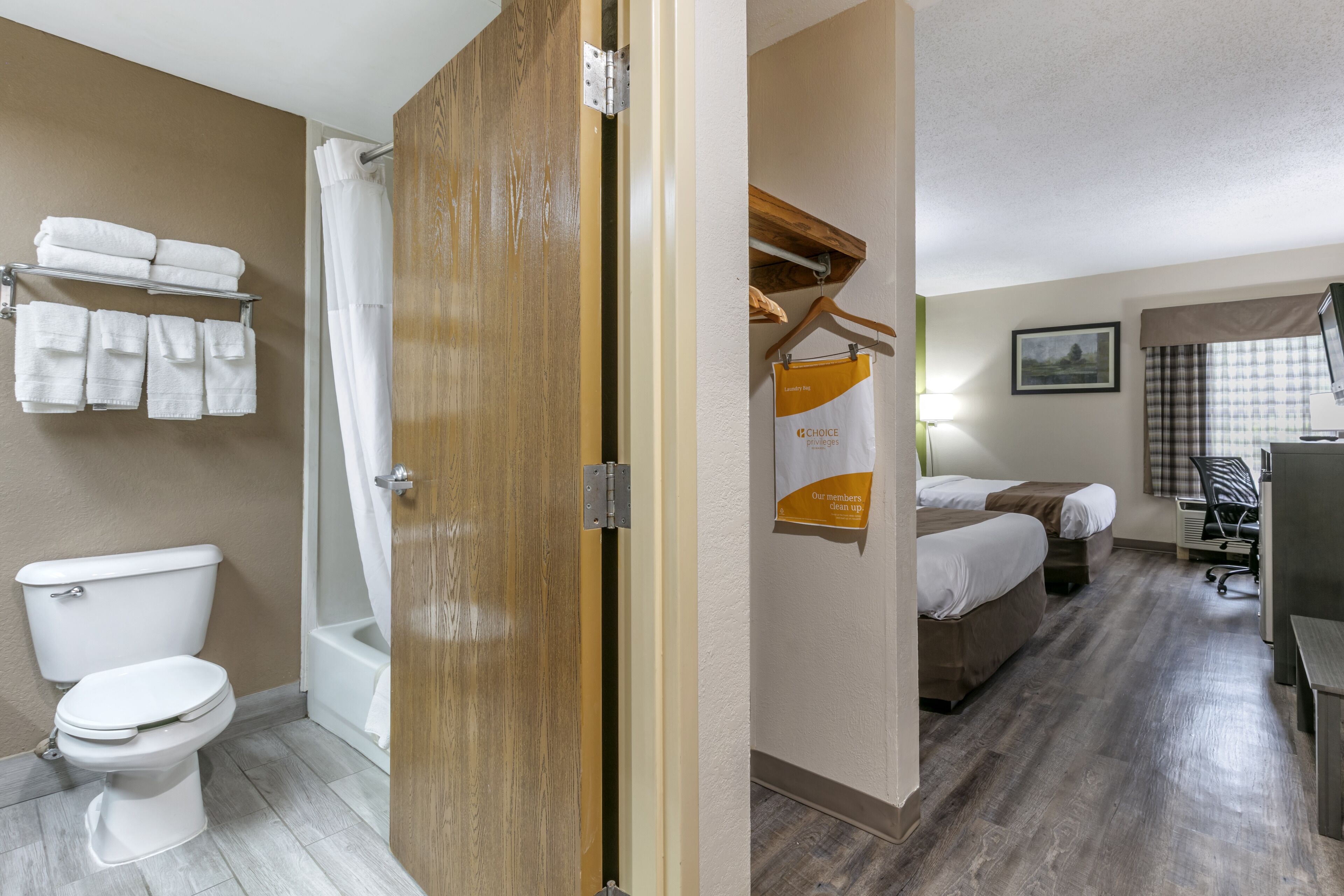 Une salle de bain d’hôtel équipée de toilettes, d’une douche et d’un porte-serviettes.