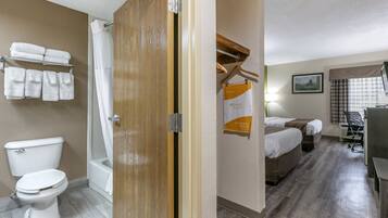 Une salle de bain d’hôtel équipée de toilettes, d’une douche et d’un porte-serviettes.