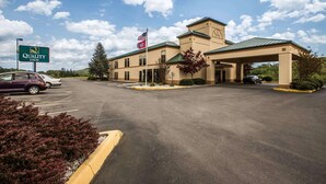 A Quality Inn with a large parking lot, a flag, and a sign. - Quality Inn Rogersville (Rogersville)
