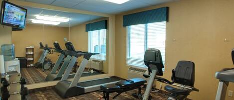 A fitness center with treadmills, elliptical machines, and free weights.
