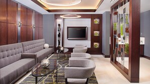 A modern living room with a grey sofa, a coffee table, and a TV mounted on the wall. - Dallas Marriott Suites Medical/Market Center (Dallas)