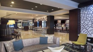 A spacious lobby with a modern bar area, seating arrangements, and a mix of contemporary and classic decor. - Dallas Marriott Suites Medical/Market Center (Dallas)
