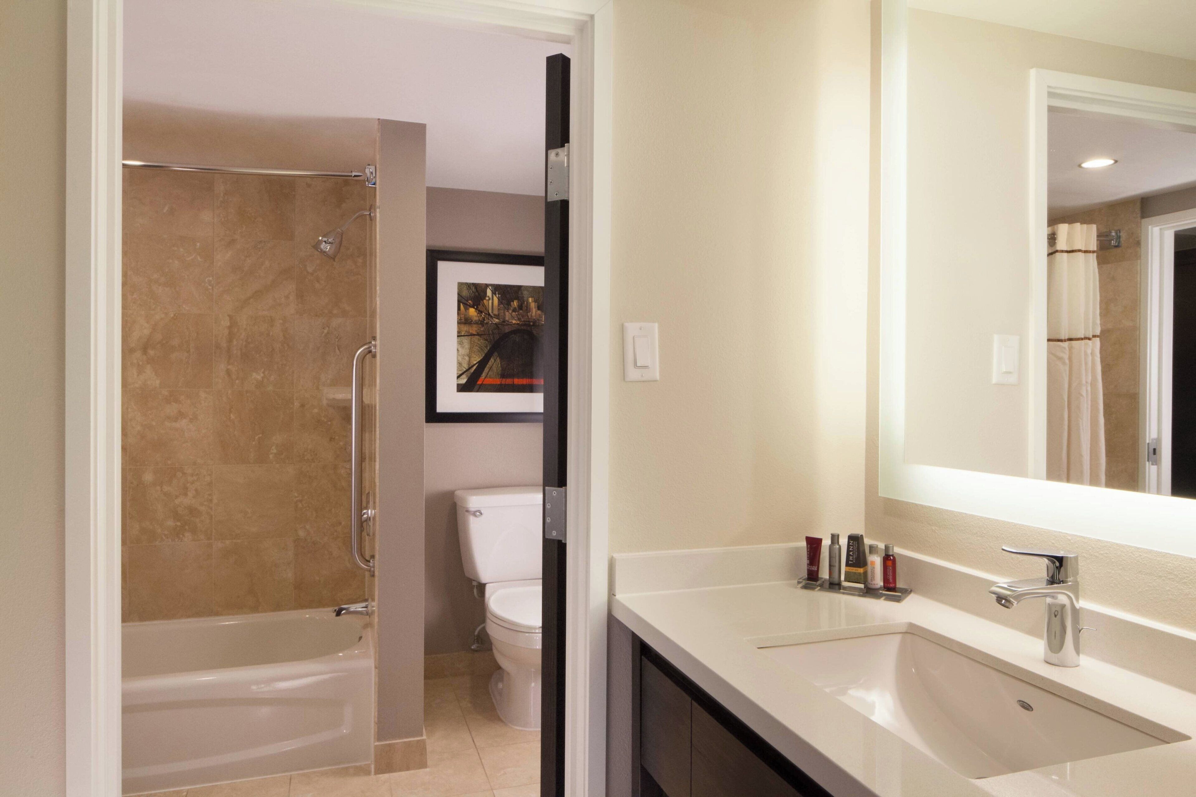 A modern bathroom with a bathtub, toilet, and sink.
