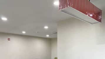 Uma área de jantar moderna com uma ilha central e mesas e cadeiras ao redor.