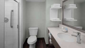 Un baño moderno con ducha, inodoro y lavamanos.