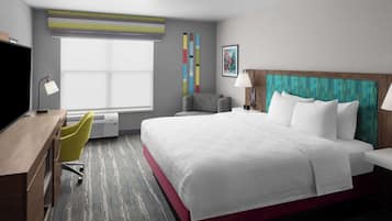 A hotel room with a large bed, a desk, a chair, and a window with blinds.