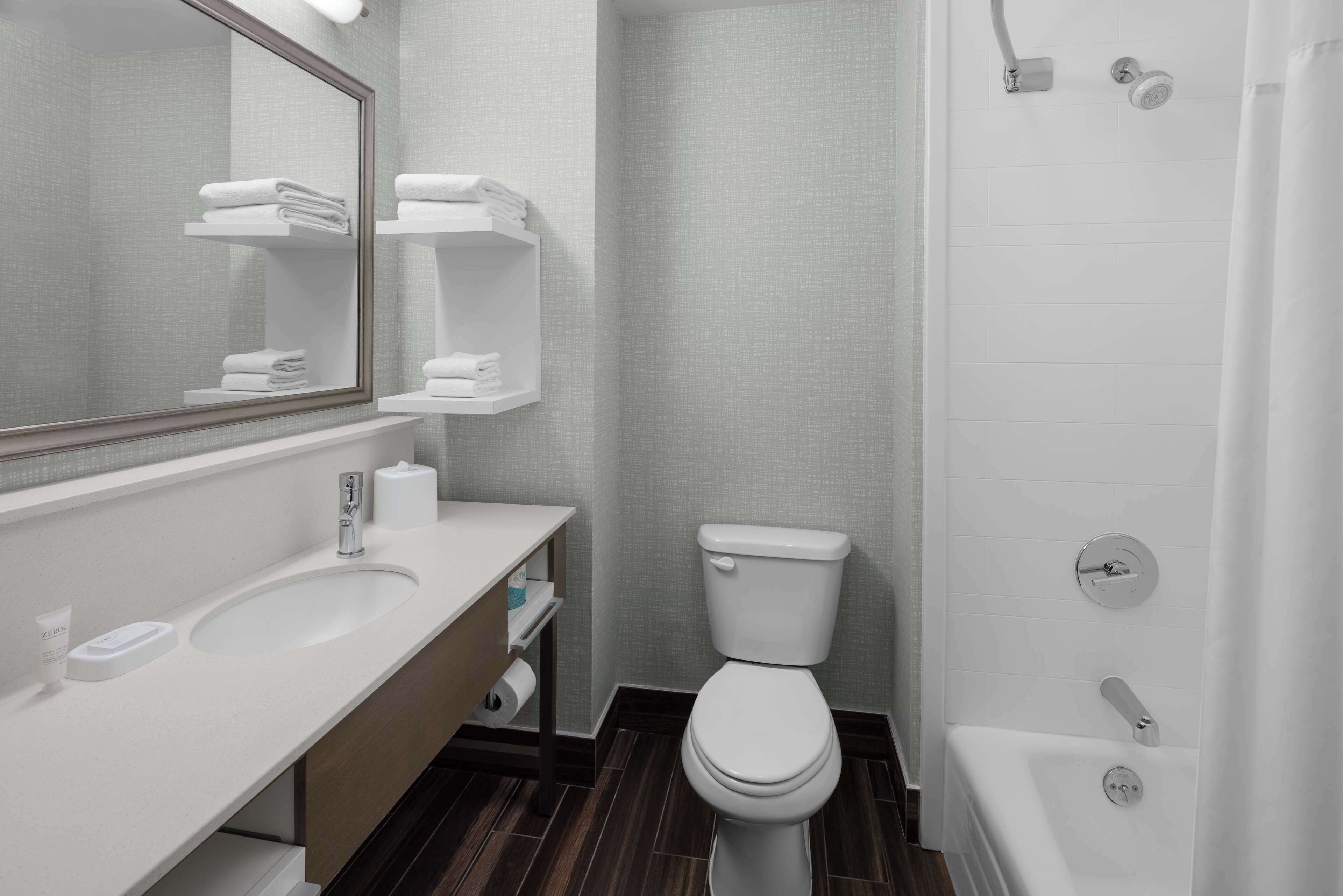 Une salle de bain moderne avec un lavabo, des toilettes et une baignoire, le tout de couleur blanche.