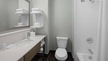 Une salle de bain moderne avec un lavabo, des toilettes et une baignoire, le tout de couleur blanche.