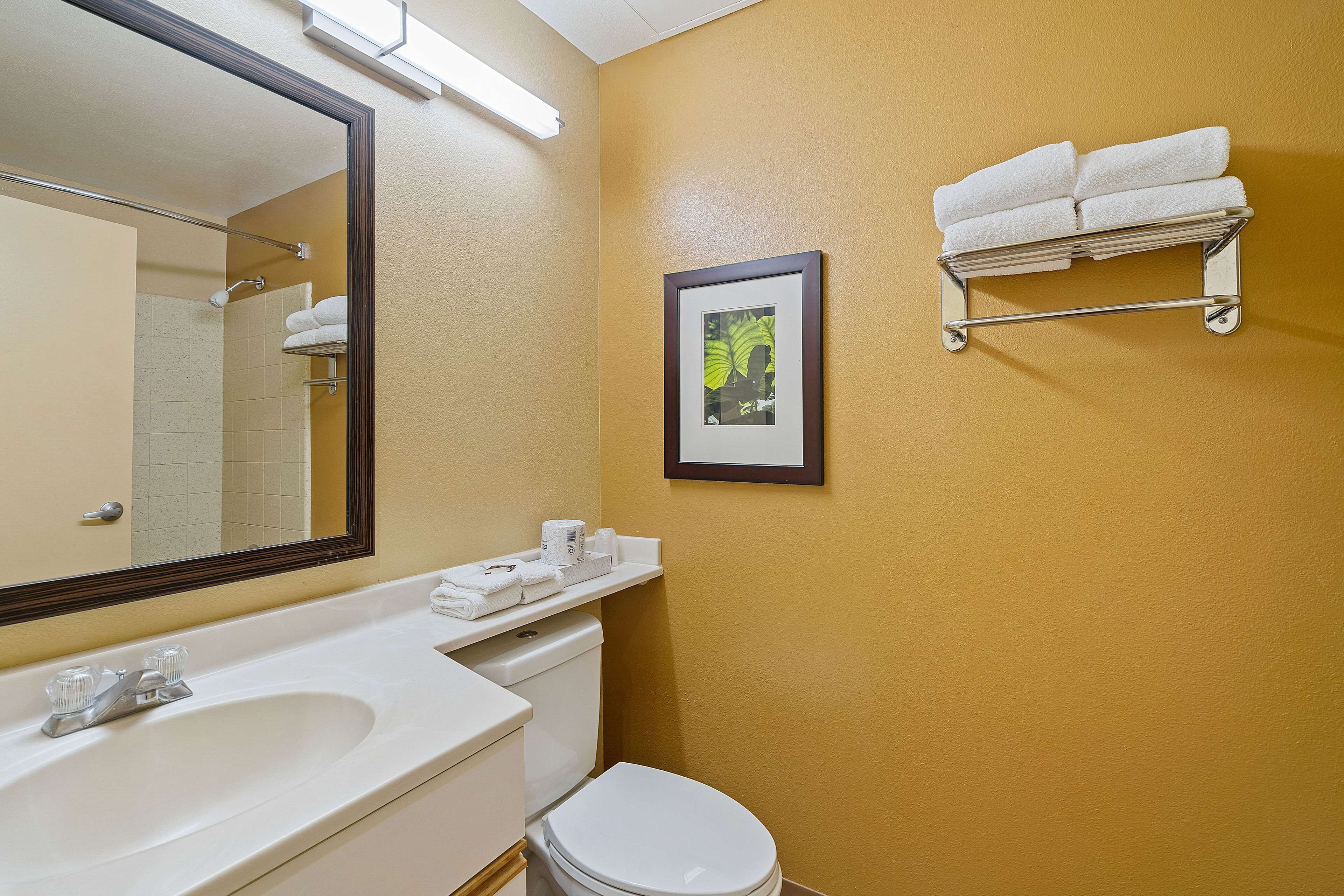 A bathroom with a sink, toilet, and a towel rack with towels.