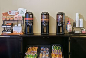 Una estación de café con tres dispensadores de café: uno para café caliente, uno para tueste claro y uno para tueste oscuro.
