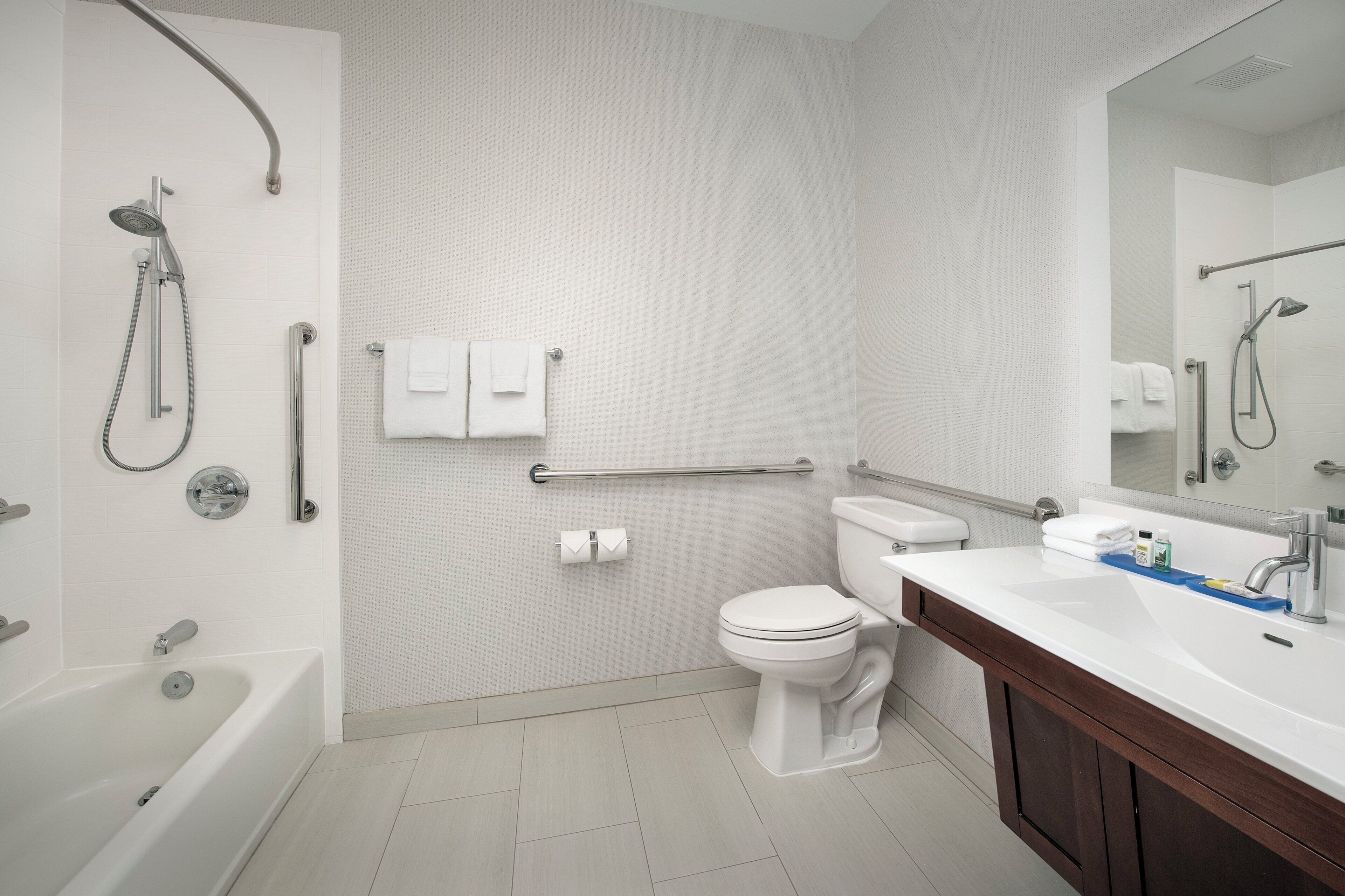 A modern bathroom with a bathtub, toilet, and shower area.