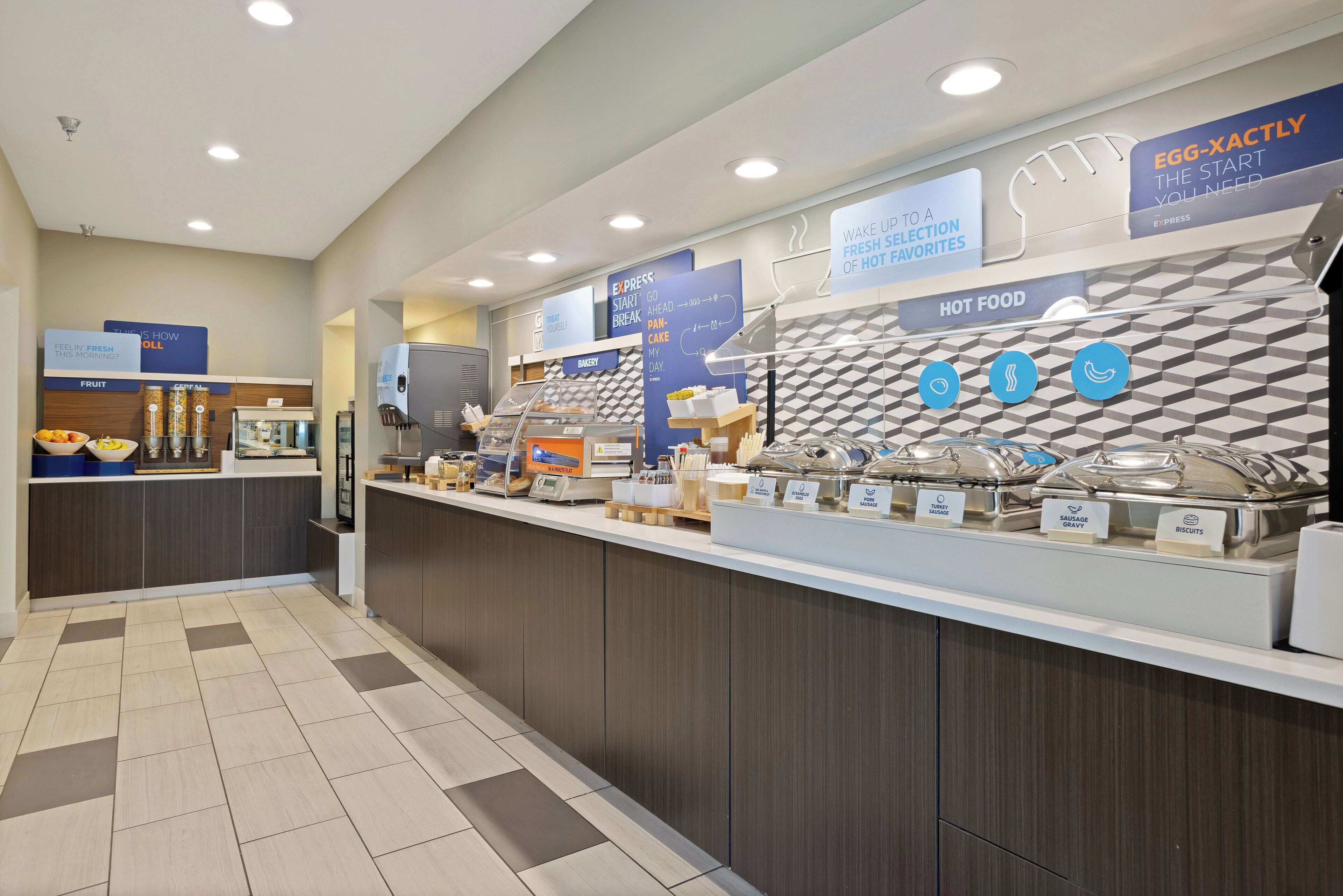 A breakfast bar with various food options, including a bakery and hot food section.