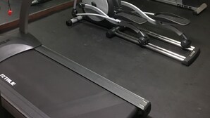 Une salle de sport équipée de nombreux appareils d’exercice, notamment des tapis de course et des appareils de musculation elliptique.