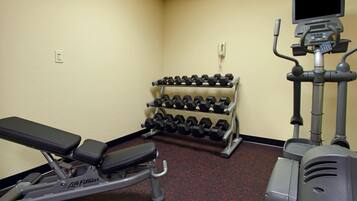 Una palestra con panche, manubri e attrezzature cardio.