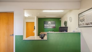 A reception area with a green wall, a reception desk, a digital kiosk, and a framed map on the wall. - HomeTowne Studios By Red Roof Denver - Airport/ Aurora (Aurora)
