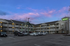 A multi-story motel with a parking lot. - HomeTowne Studios By Red Roof Denver - Airport/ Aurora (Aurora)
